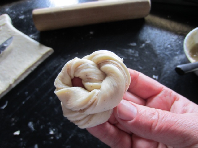 ... and wrap the twisted strip of dough around your hand. Tuck the end underneath, and plunk it down on the cookie sheet. Use baking paper or silpat baking sheets to prevent them from sticking.